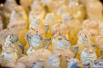 basket with white angel-shaped candles at the Christmas market, close-up, selective focus
