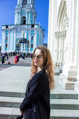 Fototapeta premium A young woman in front of the Trinity-Sergius Lavra in Sergiev Posad. Moscow region. Russia. came out