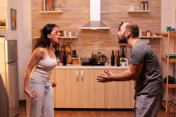 Angry couple with alcohol problems. Abused terrified beaten wife covered in bruises suffering...