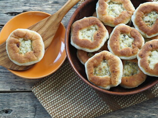 Country style. Homemade cakes, belyashi, in a plate on a wooden background with a wooden kitchen spatula.