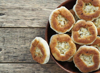 Homemade pastries, belyashi, in a plate on a wooden background.Rustic style.