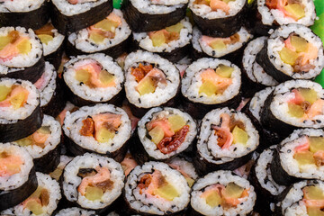 Top view of stack of Japanese sushi maki roll plate. Served in Japanese bar restaurant with chopstick