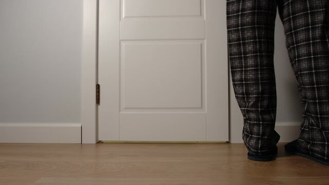 Aged man in pajamas runs into a toilet in the night