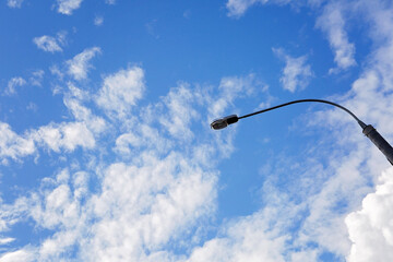 Lantern against a blue sky with white clouds