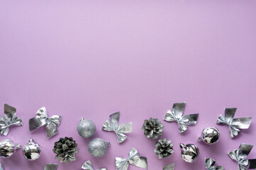 Christmas or new year composition with various silver decorations on a lilac background. Space for text
