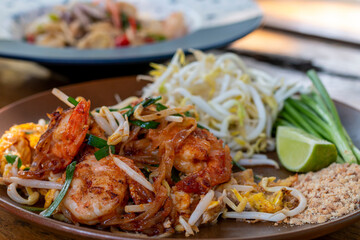 Pad Thai, Traditional stir-fried rice noodle dish commonly served as a street food and at most restaurants in Thailand as part of the country's cuisine. Stir fry noodles with sweet savoury sour sauce.