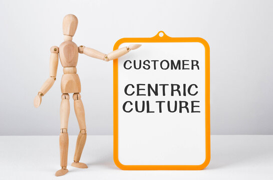 Wooden Man Shows With A Hand To White Board With Text Customer Centric Culture