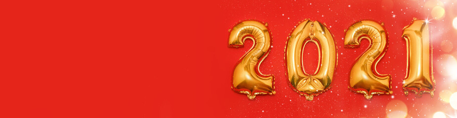Banner. Happy New year 2021 celebration. Golden helium balloon numbers 2021 and snow on red bakground. Flat lay. Copy space for text