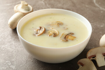 Bowl of tasty mushroom soup on gray background