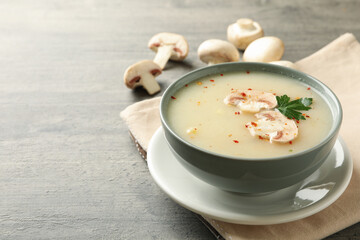 Concept of tasty lunch with bowl of mushroom soup on gray background