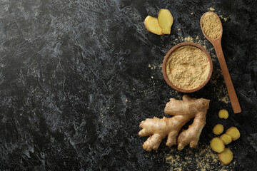 Ginger and bowl with ginger powder on black smoky background © Atlas