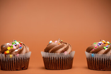 Chocolate cupcakes on beige background. Sweet dessert. Bakery concept. Delicious food.