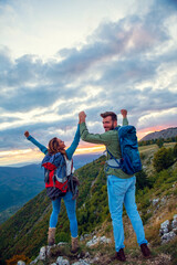 Couple on Top of a Mountain Shaking Raised Hands