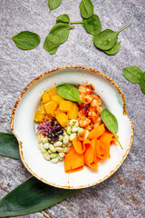 Juicy light delicious delicious salad of fresh vegetables, shrimp, edamame beans, Basil leaves, mango