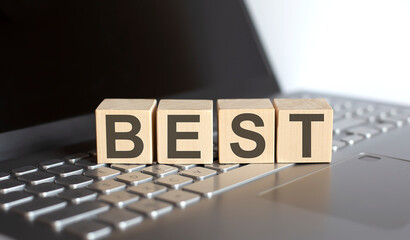 wooden blocks with BEST text of concept on the laptop