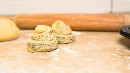 raw cruffins before baking in the oven. puff pastry croissant similar to a muffin rolled into a roll. modern baking. close-up, space for text. horizontal frame