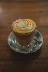 cup of cappuccino with milky foam on the wooden table