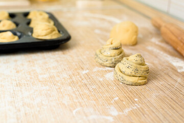 raw cruffins before baking in the oven in an iron mold. puff pastry croissant similar to a muffin rolled into a roll. modern baking. close-up, space for text. horizontal frame