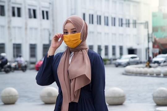 Asian muslim woman wearing hijab or jilbab and fabric mask at malioboro area, Yogyakarta. covid-19 virus pandemic new normal concept