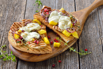 Großer Toast mit gegrillter Kräuter-Hähnchenbrust, Mango, Granatapfelkernen und Mozzarella-Käse - Toasted panini with grilled chicken breast fillet, mango, pomegranate seeds and melted mozzarella
