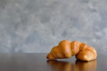 Two croissants on the bakery table after baked from the oven, ready to serve or sell at the bakery shop or coffee cafe