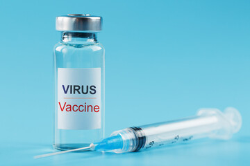 Ampoule and syringe with the vaccine against the Virus against diseases on a blue background.
