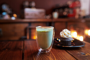 Cup of matcha drink on the wooden table in cafe.