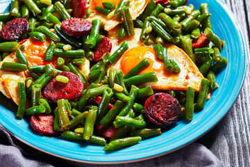 Green beans fried eggs and chorizo on a blue plate