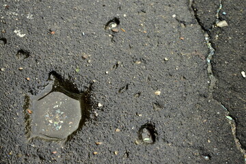 water in a small pit on the asphalt