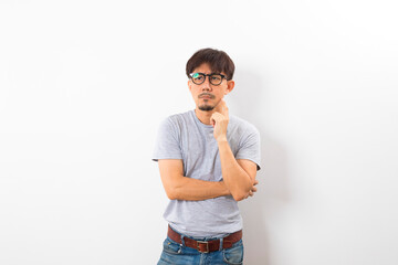 Asian adult with glasses on grey T-shirt thinking and looking outside on white background.