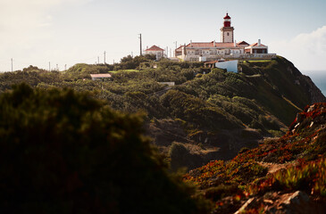 Fototapeta na wymiar Famous lighthouse on Cabo da Roca, the western point of Europe. Beautiful landscape. Day time on the sea shore.