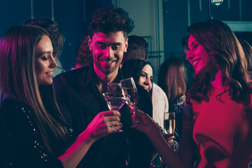 Photo portrait of trio of students drinking champagne together at nightclub in neon lights