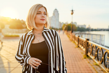 Obraz premium Outdoor portrait of happy young woman on city promenade.