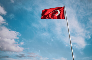 National Turkish flag waving against blue sky.