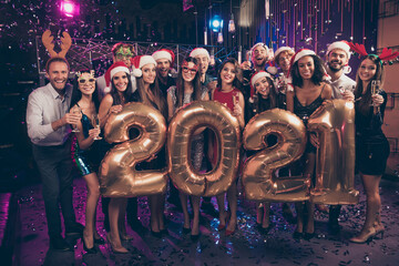 Fototapeta na wymiar Photo portrait of happy group with 2021 balloons at new year party wearing reindeer hats santa caps glasses confetti