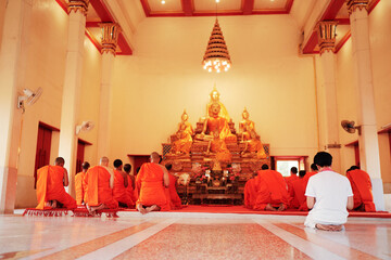 Buddhist monks kneels down prayer in temple Wat Chalong, Phuket, Thailand.