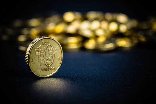 Macro photo of many Swedish 10-krona coins. Selective focus - shallow depth of field. Dark setting.