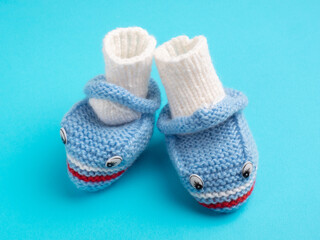Baby blue knitted shoes on a blue background