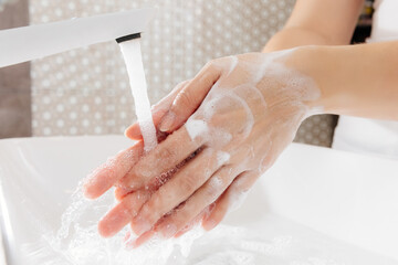 the woman carefully washes her hands with antibacterial soap. this is very important during the coronavirus epidemic. 