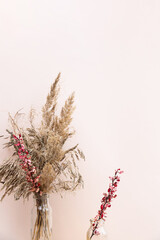 Obraz premium Dried flowers. Field dry spikelets and herbs in vases on a light pink background. Autumn still life