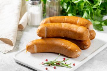 Sausages Bockwurst. Sausages Bockwurst on white serving Board on a light gray table. German sausages closeup