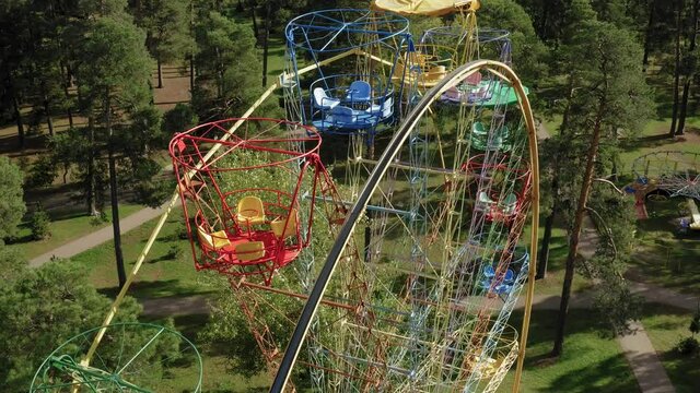 Flight Over The Ferris Wheel. Ferris wheel at park. Close-up shot of colorful ferris wheel. Old Soviet Ferris Wheel abandoned during pandemic. City quarantine aerial