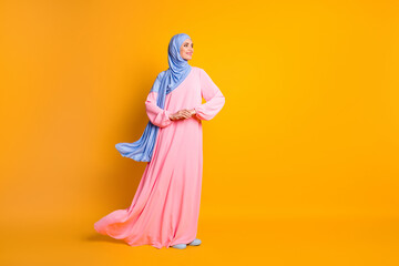 Full length body size view of pretty cheery feminine muslimah wearing hijab dress festal day isolated on bright yellow color background
