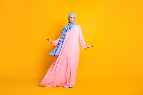 Full length body size view of nice lovely cheery feminine muslimah wearing hijab dress posing isolated shine yellow color background
