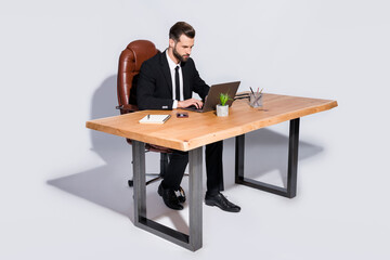 Full body photo of handsome business guy notebook table chatting colleagues read corporate report wear black blazer shirt pants shoes costume sitting chair isolated grey background