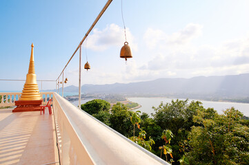 Panoramic view on Ko Samui city from a top of Wat temple where small golden bells are hanging.