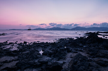 Dusk and dawn on the sea shore. Beautiful sunset on the rock beach.