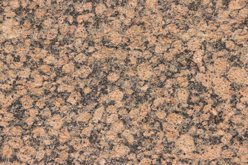 The texture of a variegated speckled polished marble slab.