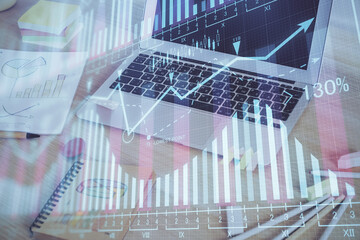 Obraz premium Financial chart drawing and table with computer on background. Multi exposure. Concept of international markets.