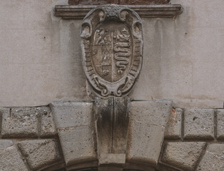 medieval shield with the snake symbol of Milan carved on the entrance of an ancient palace.Lombardy,Italy